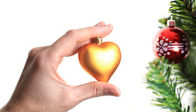 mano-que-adorna-el-árbol-de-navidad-con-el-corazón-de-oro-11766123